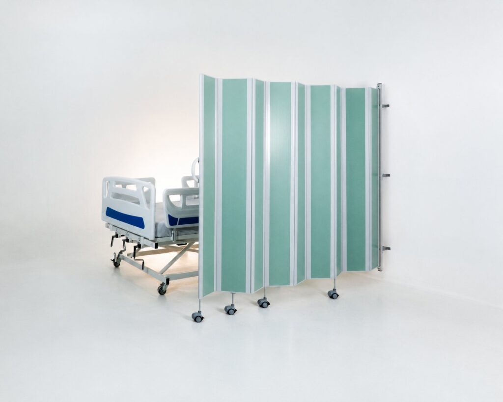 Biombo hospitalar TWB personalizado ao lado de cama hospitalar, ilustrando divisoria retratil para clinicas e hospitais
